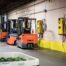 Toyota forklifts beside warehouse charging equipment