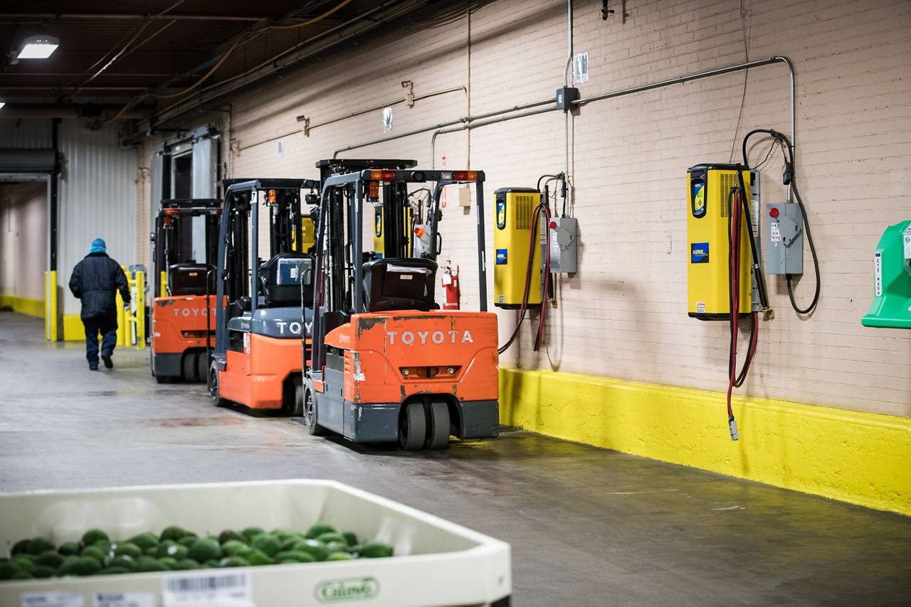 Toyota forklifts beside warehouse charging equipment