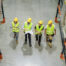 Four people reviewing a warehouse floor from above