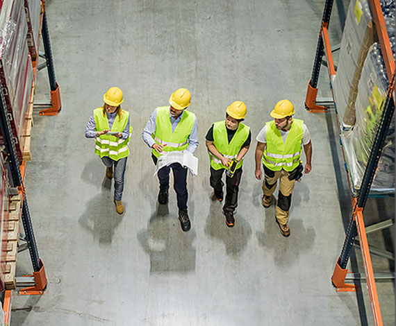 Four people reviewing a warehouse floor from above